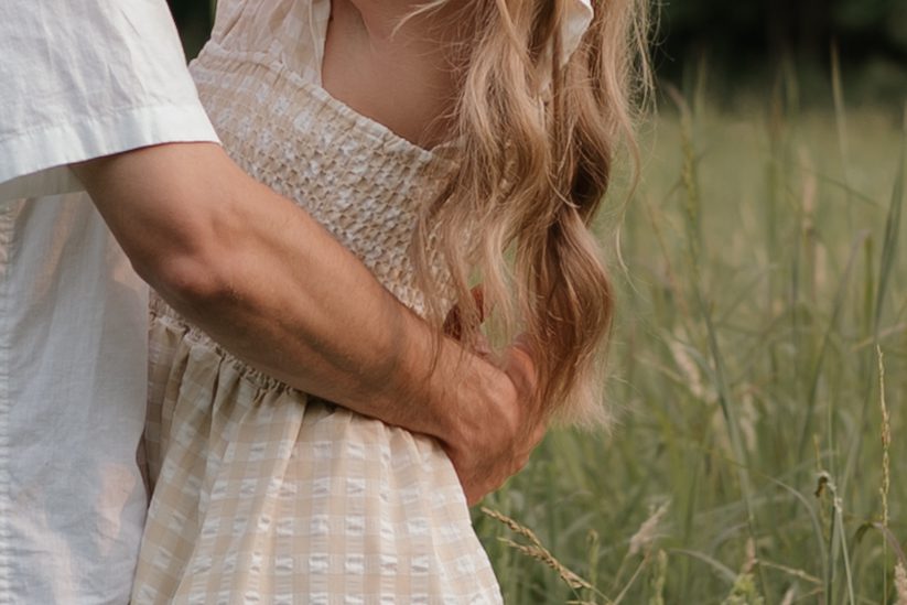 Couple in a sunlit field at Price Park in Greensboro, NC during golden hour