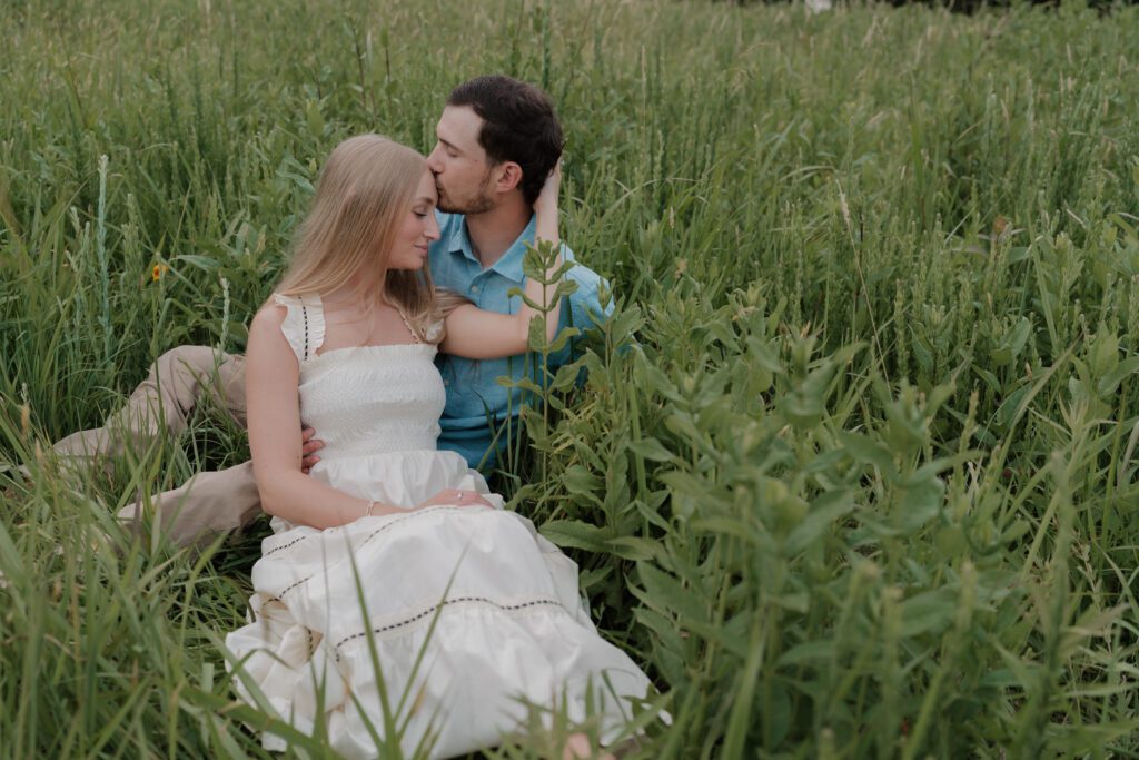 Couple walking hand-in-hand through a sunlit field at Price Park in Greensboro, NC during golden hour