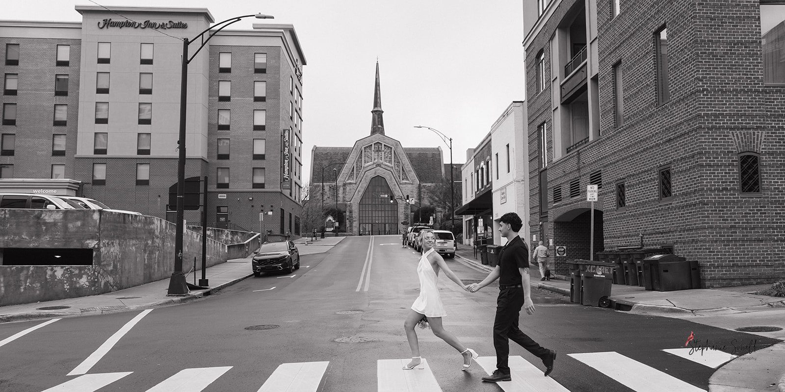 downtown winston salem engagement photos couple walking crosswalk