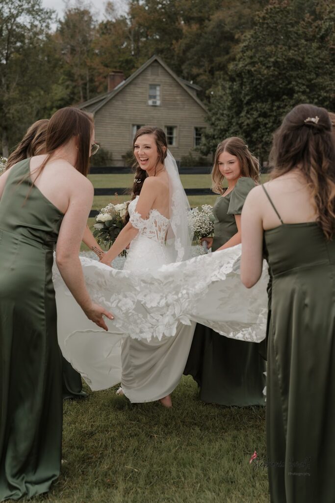 Bride smiling at bridesmaids during Oakland Farms wedding portraits in Sanford North Carolina