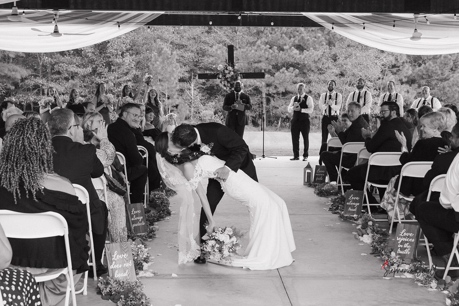 Bride and groom first kiss during ceremony at Oakland Farms Wedding Venue in Sanford NC